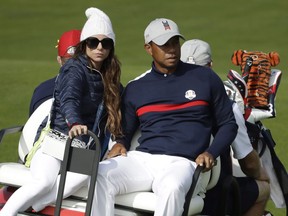 Tiger Woods drives away in a buggy with his then-partner Erica Herman after his fourball match on the opening day of the 42nd Ryder Cup at Le Golf National in Saint-Quentin-en-Yvelines, France, Friday, Sept. 28, 2018.