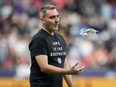 Vancouver Whitecaps head coach Vanni Sartini tosses a water bottle in the air as he leaves the field after the first half of an MLS soccer match against Los Angeles FC last week.