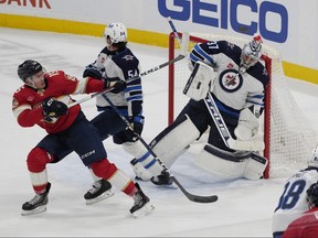 Winnipeg Jets goaltender Connor Hellebuyck (37) stops a shot on goal by Florida Panthers centre Anton Lundell (15) during the second period in Sunrise, Fla.