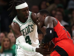 Celtics' Jrue Holiday (left) and Raptors' Dennis Schroder (right) battle for control of the ball during NBA action at TD Garden in Boston, Saturday, Nov. 11, 2023.