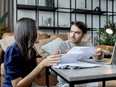 Couple discussing their end-of-life planning at table with laptop and papers on table.