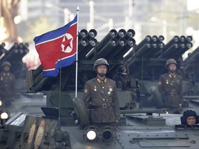 North Korean soldiers stand on armoured vehicles with rocket launchers as they parade in Pyongyang, North Korea on Oct. 10, 2015.