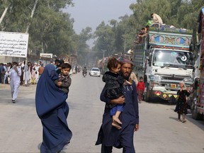 An Afghan family walk toward their truck after registration at a UNHCR voluntary repatriation center for retuning to their homeland, in Peshawar, Pakistan, Monday, Oct. 30, 2023.