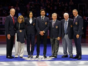 From left, Tom Barrasso, Coco Lacroix (for Pierre), Caroline Ouellett, Henrik Lundqvist, Mike Vernon, Ken Hitchcock and Pierre Turgeon receive their Hockey Hall of Fame blazers at Scotiabank Arena on Nov. 12, 2023 in Toronto.