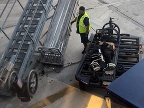 Screengrab of wheelchair getting launched off ramp while baggage handler watches