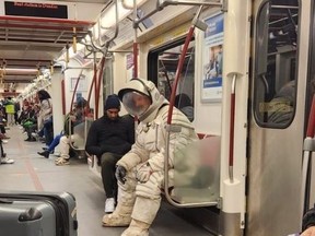 Someone dressed in an astronaut outfit is seen sitting in a TTC subway car on Thursday, Nov. 30, 2023.