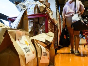 A cart is overflowing with pre-filled bags of food, during a Thanksgiving food drive for the Ottawa Food Bank at a grocery store in Ottawa, on Saturday, Oct. 7, 2023.