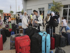 Palestinians arrive at the border crossing to Egypt in Rafah, Gaza Strip, on Monday, November 13, 2023. Canadians who escaped the Gaza Strip are desperate to help the family they behind, but say Canada's definition of family means their loved ones' lives are in danger indefinitely.