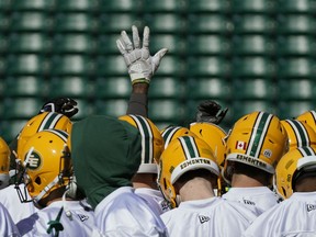 A lone hand is raised in a team huddle during Edmonton Elks training camp at Commonwealth Stadium on May 20, 2019.