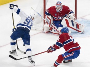 Lightning's Steven Stamkos takes a shot on Canadiens goaltender Sam Montembeault while captain Nick Suzuki backchecks during Tuesday night's game at the Bell Centre.