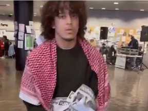 Keffiyeh, check! This guy is another ripping up posters. SCREENGRAB