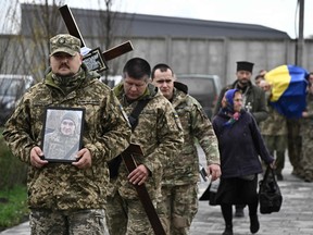 Ukrainian servicemen carry the coffin of late Ukrainian serviceman Vitalii Kaminsky, during a funeral ceremony at the cemetery in Bucha, outside Kyiv on Nov. 6, 2023, amid the Russian invasion of Ukraine.