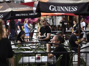 A server works on the patio of a pub in the ByWard Market in Ottawa, on Friday, June 23, 2023.