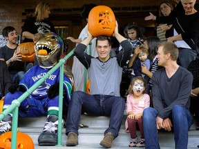 Making their day special, Canucks captain Henrik Sedin, right, and Bo Horvat, left, were on hand for a special Halloween visit to Canuck Place for sick children in Vancouver on Oct. 26, 2015.