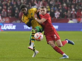 Jamaica's Demarai Grav (left) battles for the ball with Canada's Alistair Johnston during second half CONCACAF Nations League quarterfinal action in Toronto, on Tuesday, November 21, 2023. Canada has dropped three places to No. 48 in the latest FIFA world rankings in the wake of its CONCACAF Nations League quarterfinal loss to Jamaica.