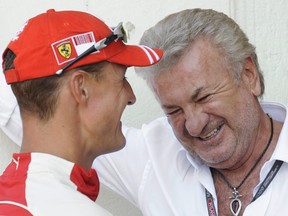 Former Formula One champion Michael Schumacher of Germany talks with sports manager Willi Weber. in 2009.