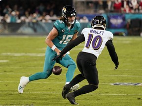 Jacksonville Jaguars quarterback Trevor Lawrence fumbles the ball as Baltimore Ravens cornerback Arthur Maulet (10) closes in.