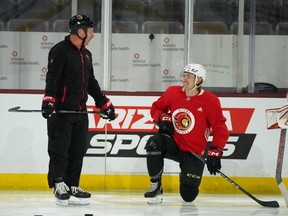 Daniel Alfredsson chats with Jake Sanderson during Ottawa Senators practice on Tuesday.