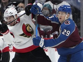 Ottawa Senators defenceman Travis Hamonic (left) jostles for position in front of the net with Colorado Avalanche centre Nathan MacKinnon during the second period of an NHL game on Dec. 21, 2023, in Denver.