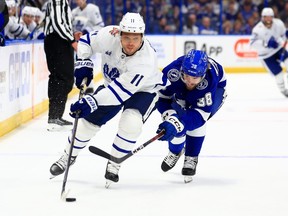 Max Domi (11) of the Toronto Maple Leafs and Brandon Hagel (38) of the Tampa Bay Lightning fight for the puck in the third period during a game at Amalie Arena on Oct. 21, 2023, in Tampa, Fla.