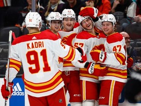 Calgary Flames defenceman Nick DeSimone (57) celebrates his first NHL goal with teammates, after scoring against the Anaheim Ducks at Honda Center in Anaheim on Thursday, Dec. 21, 2023.