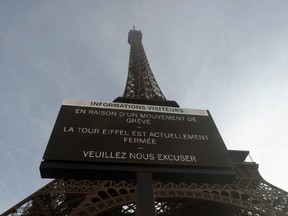 This photograph taken on December 27, 2023 shows a board informing visitors that the site is closed after staff went on strike, at the bottom of the Eiffel Tower in Paris. The strike on the 100th anniversary of the death of engineer Gustave Eiffel, who built the tower, was to protest about "the current way it is managed", the hard-left CGT union said in a statement.