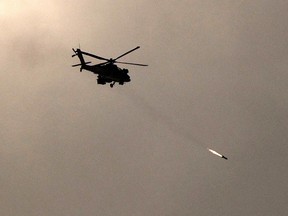 A picture taken from a position in southern Israel along the border with the Gaza Strip on December 29, 2023 shows an Israeli military helicopter firing a missile towards Gaza amid continuing battles between Israel and the militant group Hamas.
