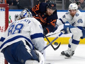 The Edmonton Oilers' Leon Draisaitl (29) battles past the Tampa Bay Lightning's Nicklaus Perbix (48) to get a shot off against goalie Andrei Vasilevskiy (88) during first period NHL action at Rogers Place, in Edmonton Thursday Dec. 14, 2023.