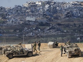 Israeli soldiers take up positions near the Gaza Strip border, in southern Israel, Friday, Dec. 29, 2023.