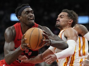 Toronto Raptors forward Pascal Siakam, left, controls the ball as Atlanta Hawks guard Trae Young defends during first half NBA basketball action in Toronto on Wednesday, Dec. 13, 2023.