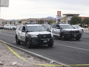 A police vehicle with bullet holes, left, is seen at the scene in the area of Blue Diamond Road and Durango Drive in Las Vegas, Wednesday, Dec. 27, 2023, after officers from two Nevada law enforcement agencies opened fire during a pre-dawn chase through Las Vegas as they tried to stop a man who fatally shot his mother, then stole a police cruiser and carjacked bystanders at gunpoint while trying to evade police, authorities said.