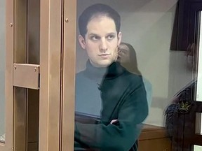 This grab from a handout footage provided by the Moscow City Court on Thursday, Dec. 14, 2023 shows U.S. journalist Evan Gershkovich, arrested on espionage charges, standing inside a defendants' cage at a hearing to consider an appeal on his extended pre-trial detention, in Moscow.