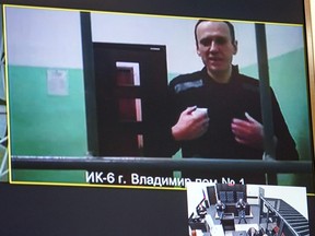 A screen shows jailed Kremlin critic Alexei Navalny as he arrives to listen to a hearing on an appeal lodged against a court decision to jail him for 19 years in a maximum security prison on extremism-linked charges, at a court in Moscow on Sept. 26, 2023.