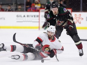 Mark Kastelic of the Ottawa Senators attempts to control the puck ahead of Michael Carcone of the Arizona Coyotes during the second period at Mullett Arena in Tempe, Ariz., on Tuesday.