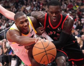 Raptors guard Dennis Schroder (right) battles for a loose ball with Utah Jazz guard Kris Dunn last night. Chris Young/THE CANADIAN PRESS