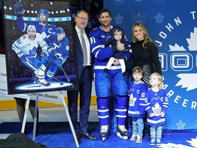 Toronto Maple Leafs captain John Tavares stands with his family and Maple Leafs general manager Brad Treliving (left) as he is honoured for recording his 1000th NHL point in a ceremony in Toronto on Dec. 19, 2023.