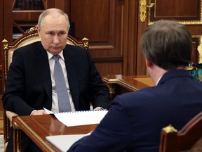In this pool photograph distributed by Russian state agency Sputnik, Russia's President Vladimir Putin (left) meets with Director General of Aeroflot Russian Airlines Sergei Aleksandrovsky at the Kremlin, in Moscow, Friday, Dec. 29, 2023.