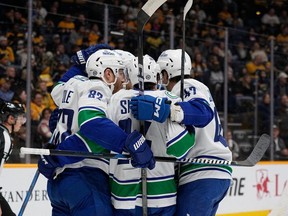 Vancouver Canucks players celebrate a goal during the first period of an NHL hockey game against the Nashville Predators, Tuesday, Dec. 19, 2023, in Nashville, Tenn.