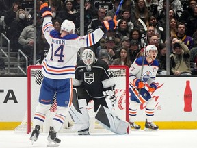 Edmonton Oilers center Connor McDavid, right, and defenseman Mattias Ekholm, left, celebrate a goal by center Leon Draisaitl as Los Angeles Kings goaltender Cam Talbot stands at goal during the second period of an NHL hockey game Saturday, Dec. 30, 2023, in Los Angeles.