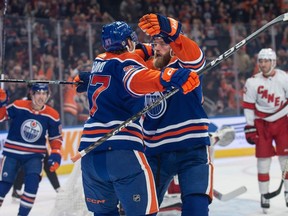 Connor McDavid (97) and Mattias Ekholm (14) of the Edmonton Oilers, celebrate a first period goal against the Carolina Hurricanes at Rogers Place in Edmonton on Dec. 6, 2023.