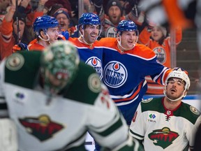 Connor McDavid (97), Evan Bouchard (2) and Zach Hyman (18) of the Edmonton Oilers, celebrate a first period goal against the Minnesota Wild at Rogers Place in Edmonton on Dec.8, 2023.