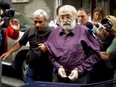 Romanian guru Gregorian Bivolaru is escorted to a vehicle, after a hearing at the Romanian Police headquarters in Bucharest, Romania, Wednesday, Aug. 24, 2016.