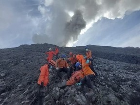 In this undated photo released Dec. 5, 2023, by the Indonesian National Search and Rescue Agency (BASARNAS), rescuers prepare to evacuate the body of a climber killed in Mount Marapi's eruption in Agam, West Sumatra, Indonesia. Rescuers searching the hazardous slopes of Indonesia's Marapi volcano found more bodies among the climbers caught by a surprise eruption two days ago.