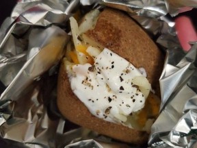 Small baked potato with sour cream and cheese.