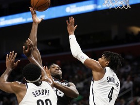 Detroit Pistons centre Isaiah Stewart (28) shoots against Brooklyn Nets centre Day'Ron Sharpe (20) and guard Dennis Smith Jr. (4) during the first half of an NBA basketball game Tuesday, Dec. 26, 2023, in Detroit.