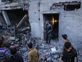 Palestinians check damage after an Israeli strike in Rafah in the southern Gaza Strip on December 3, 2023.