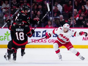 Ottawa Senators centre Tim Stutzle and left wing Brady Tkachuk collide as Carolina Hurricanes centre Sebastian Aho looks for the puck during the first period in Ottawa on Tuesday, Dec. 12, 2023.