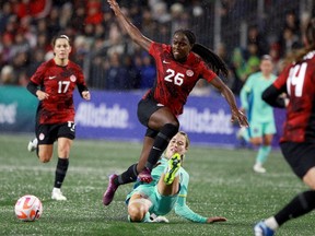 Canada's Simi Awujo avoids a tackle by Australia's Courtney Nevin during first half soccer action at Starlight Stadium in Langford, B.C., on Friday, December 1, 2023.