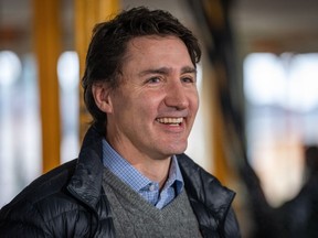 Justin Trudeau smiles at the media before a news conference for a housing announcement in Vancouver, B.C., Friday, Dec. 15, 2023.