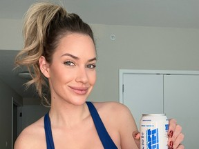 Paige Spiranac poses in a blue crop top in a social media post.